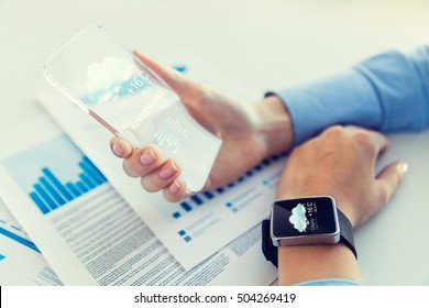 business, technology, weather, forecast and people concept - close up of woman hand holding transparent smartphone and smartwatch with cloud and air temperature settings on screen - Powered by Shutterstock