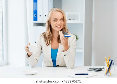 business, tecnology, communication and people concept - happy businesswoman drinking coffee and using voice command or recorder on smartphone at office - Powered by Shutterstock