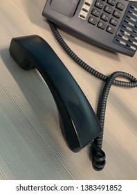 Business telephone with handset off the hook.