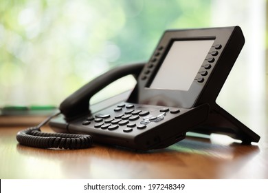 Business telephone with liquid crystal display on a desk in an office