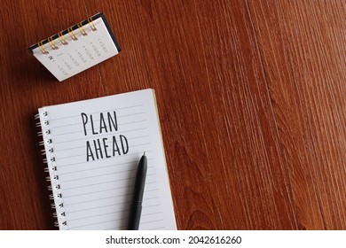 Business, Time Management Concept. Top View Of Desk Calendar And Notebook With Text PLAN AHEAD. Copy Space For Text