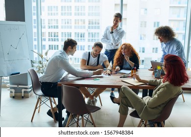 A Business Transaction In Progress, A Couple Being Persuade To Invest Into A Business. A Businessman Convincing A Woman To Sign A Contract While Her Partner Is Reading The Details.