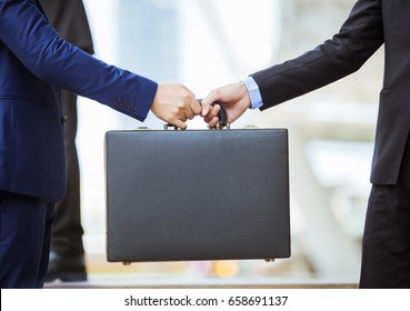 Business Transfer Deal. Handover Of A Suitcase In The Hands Of Partners.