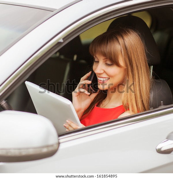 business travel: busy businesswoman with document and\
laptop in car