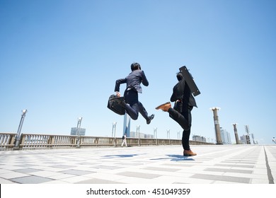 Business two men jumping on the road 