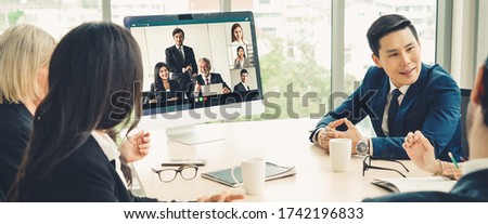 Business video conference meeting in office. People communicate with team using video call in meeting room. Smart tele video meeting connects staff from remote office.