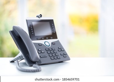 Business Voip Telephone With Liquid Crystal Display And Camera On A Desk In An Office