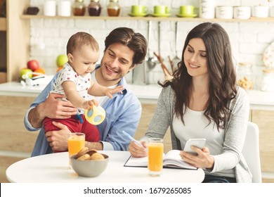Business weekends. Young woman working at kitchen, spending morning with family
