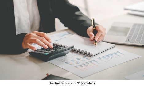 business woman or accountant who are using a calculator to calculate business data Accounting documents and laptop computer at the office business idea - Shutterstock ID 2163024649