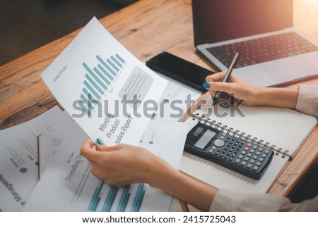 Business woman analysis summary graph reports of business operating expenses and work data about the company's financial statements.