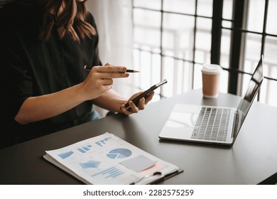 Business woman to analyze investment strategies and brainstorm sales plans for a more profitable business. - Shutterstock ID 2282575259
