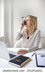 Business Woman With Asthma Inhaler At Her Desk In Office
