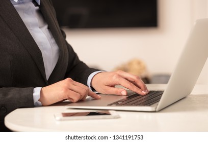 Business woman below chest working on her laptop in a cozy environment - Shutterstock ID 1341191753