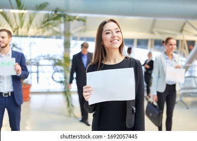 Business Woman With A Blank Welcome Sign At The Airport Terminal While Picking Up A Guest