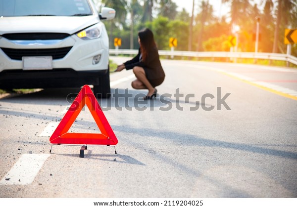 Business woman calling car insurance\
for assistance broken car on the road, signs Emergency\
.