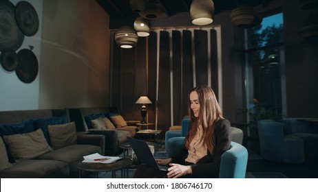 Business woman calling video chat online on laptop computer in hotel lobby. Female manager gesturing hands during video call online on notebook. Businesswoman using laptop for video call - Powered by Shutterstock