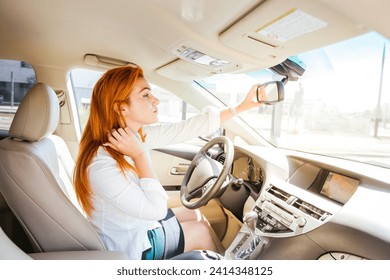 Business woman in a car checking her look in the rear-view mirror - Powered by Shutterstock