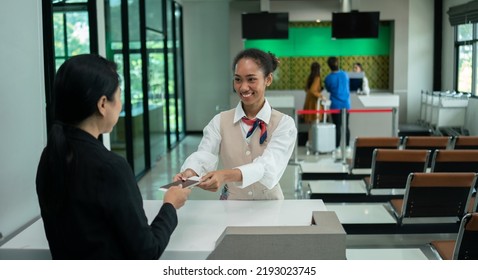 Business Woman At Check-in Counter With Airlines Staff. Airline Transportation And Tourism Concept.