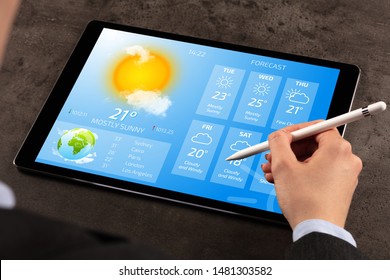 Business woman checking weekly weather forecast on tablet