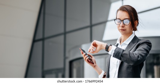 A business woman checks the time in the city during a working day waiting for a meeting. Discipline and timing. An employee goes towards a corporate meeting. - Shutterstock ID 1766992454