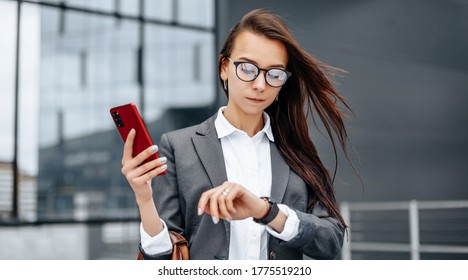 A business woman checks the time in the city during a working day waiting for a meeting. Discipline and timing. An employee goes towards a corporate meeting. - Shutterstock ID 1775519210