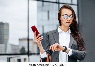 A business woman checks the time in the city during a working day waiting for a meeting. Discipline and timing. An employee goes towards a corporate meeting. - Shutterstock ID 1779453191