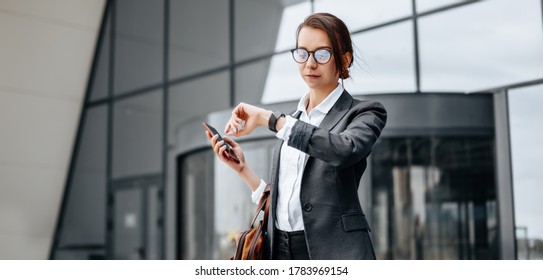 A business woman checks the time in the city during a working day waiting for a meeting. Discipline and timing. An employee goes towards a corporate meeting. - Shutterstock ID 1783969154