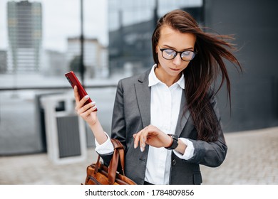 A business woman checks the time in the city during a working day waiting for a meeting. Discipline and timing. An employee goes towards a corporate meeting. - Shutterstock ID 1784809856