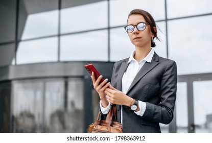 A business woman checks the time in the city during a working day waiting for a meeting. Discipline and timing. An employee goes towards a corporate meeting. - Shutterstock ID 1798363912