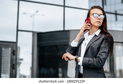 A business woman checks the time in the city during a working day waiting for a meeting. Discipline and timing. An employee goes towards a corporate meeting. - Shutterstock ID 1800291229