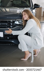 Business Woman Chossing A New Car In A Car Showroom. Happy Female Hug New Car And Very Glad