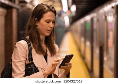 Business Woman In City Using Cell Phone At Subway Platform