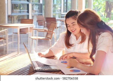 Business woman discussing the charts and graphs showing the results of their successful teamwork. Soft focus and blurred. 