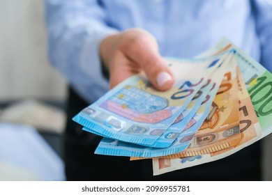 Business Woman Displaying A Spread Of Cash Euros. Close-up. Income And Business Concept. Venality, Bribe, Corruption Concept. Hand Giving Money. Millennial Candid Authentic Female Hands Counting Money