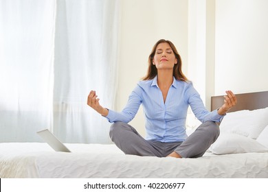 Business Woman Doing Yoga On A Bed In A Hotel Room