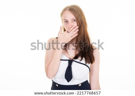 business woman in a dress suit and tie surprised with her hand on her mouth blue eyes wide open
