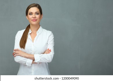 Business woman dressed white shirt standing in front of grey wall back.
