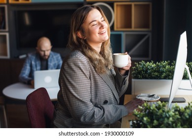 business woman drinks coffee in the office at the work table