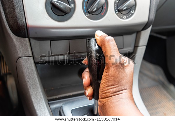 Business woman driver hand shifting the gear stick. \
Black woman\'s hand shifting the gear stick, Close up of hand of\
African American female driver shifting gear stick before driving\
car