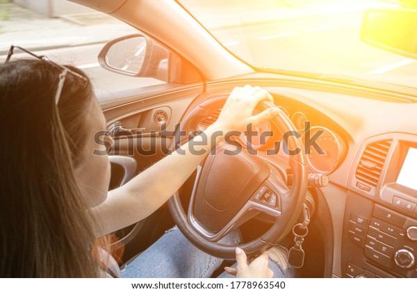 Business woman driving car. Travel car trip on road\
at sunset. Happy young man have fun ride inside vehicle in summer\
sunny day.