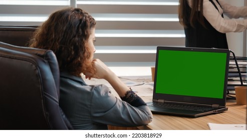 Business woman or female freelancer watching a webinar on green screen chroma key laptop. Girl looking at green screen laptop computer watching movie, video content. - Powered by Shutterstock