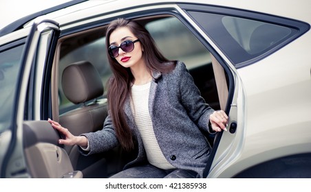 Business Woman In A Gray Coat Sitting In The Car Waiting For A Nice Person