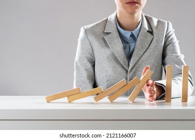 Business woman hand block domino effect. Business risk management and stabilisation situation. Life insurance company presentation with wooden blocks on table. Protection from economic crisis. - Shutterstock ID 2121166007