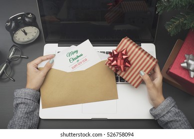 business woman hand holding christmas card and gift box on desk office concept office christmas and happy new year.