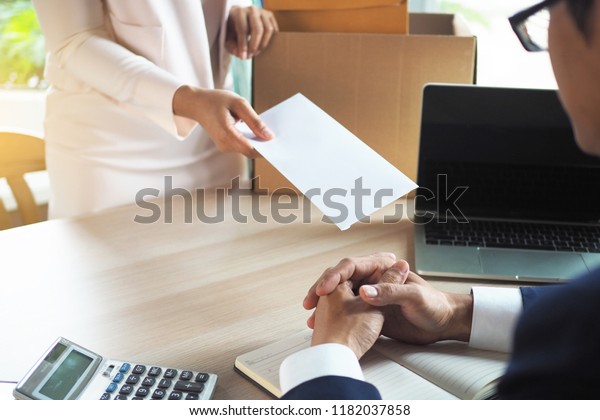 The\
business woman has a brown cardboard box next to her body and sends\
a letter of resignation to the executive. Include about\
resignation, job placement and vacancies.    \
