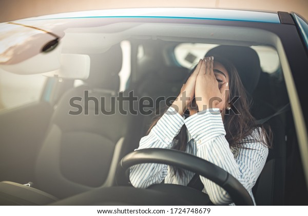 Business woman having headache taking off her glasses\
has to make a stop after driving car in traffic jam on rush hour.\
Exhausted, overworked driver concept. Stressed woman driver sitting\
in her car