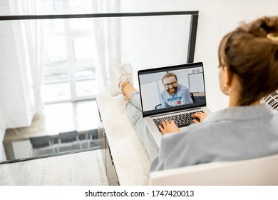 Business woman having a video call with coworker, working online from home at cozy atmosphere