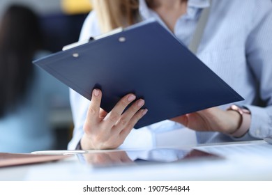 Business woman holding clipboard with documents in her hands at workplace. Management concept