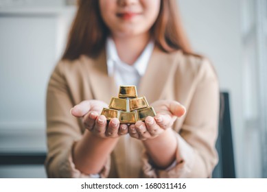 Business Woman Holding Gold Bar Stack In Her Hand