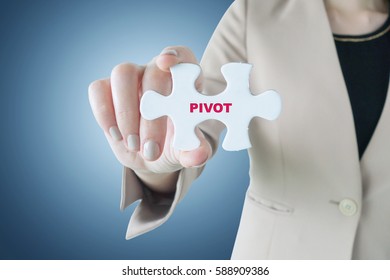 Business woman holding a piece of jigsaw puzzle with word Pivot